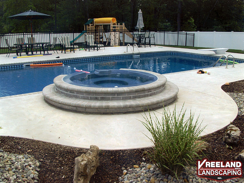 Oak Ridge, NJ, Bullnose coping, swirl finish concrete, custom plantings, paver blocks around hot tub 