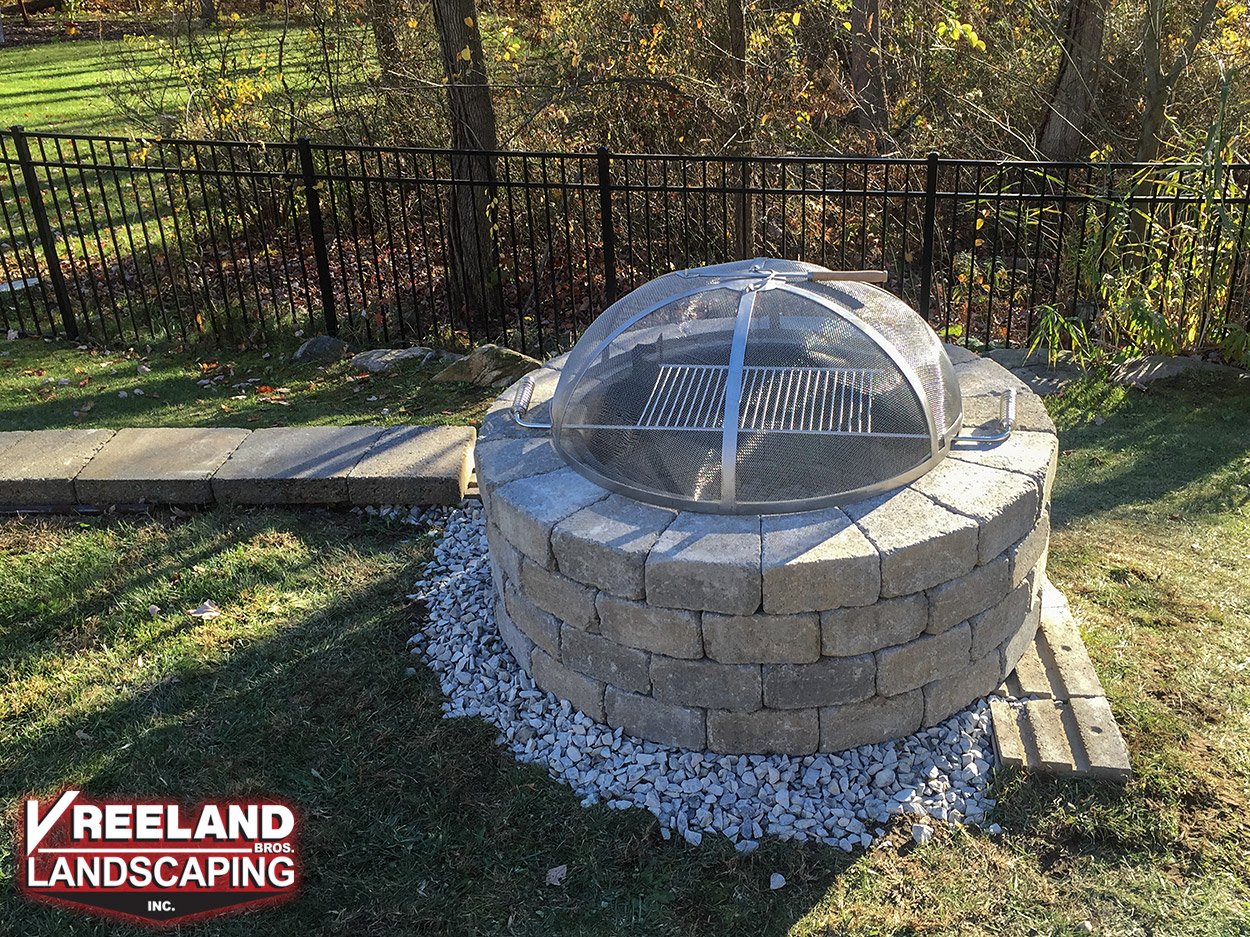 Rockaway, NJ, Custom built fire pit with grill installed at end of retaining wall.  Note the cap block has not been installed yet. 