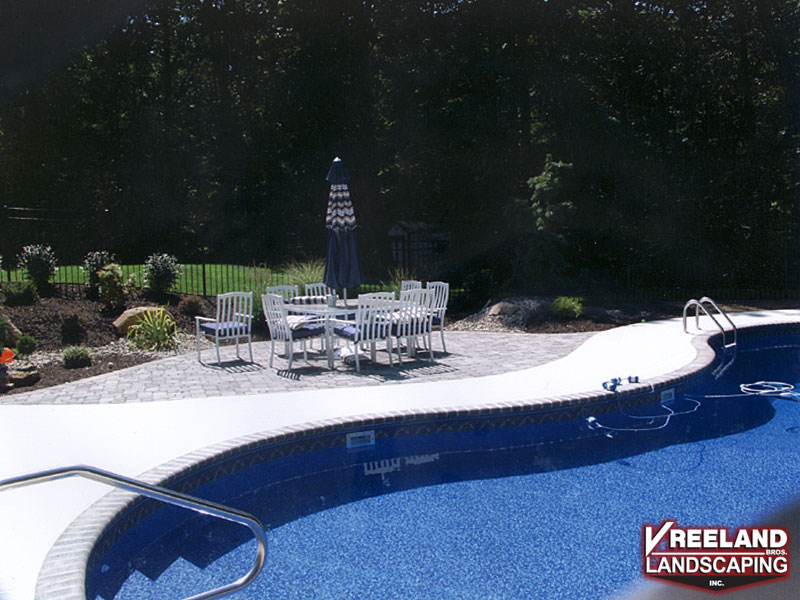 Rockaway, NJ, Existing pool was backfilled; bull nose coping, swirl finish concrete, and a paver patio installed by Vreeland Brothers. 