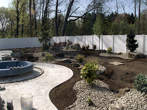 Oak Ridge, NJ - Bullnose coping, swirl finish concrete, custom plantings, paver blocks around hot tub - Vreeland Landscapes