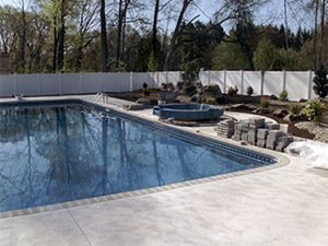 Oak Ridge, NJ - Bullnose coping, swirl finish concrete, custom plantings, paver blocks around hot tub - Vreeland Landscapes