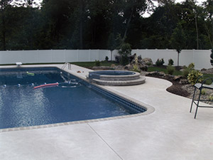 Oak Ridge, NJ - Bullnose coping, swirl finish concrete, custom plantings, paver blocks around hot tub - Vreeland Landscapes