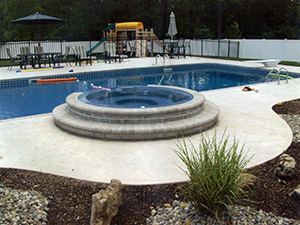 Oak Ridge, NJ - Bullnose coping, swirl finish concrete, custom plantings, paver blocks around hot tub - Vreeland Landscapes