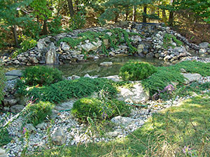 Kinnelon Estates, NJ - Wooded pond with custom waterfall, plantings, and rock gardens - Vreeland Landscapes