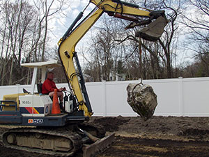 West Milford, NJ - VBL partner Wayne Vreeland removing a large boulder while grading a site - Vreeland Brothers Landscaping