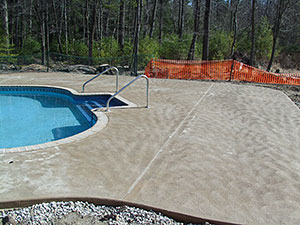 West Milford, NJ - Swirl finish concrete pool patio & bull nose coping installed around new pool - Vreeland Brothers Landscaping