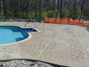West Milford, NJ - Swirl finish concrete pool patio & bull nose coping installed around new pool - Vreeland Landscapes